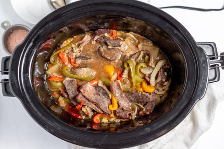 A crock pot full of meat and vegetables.
