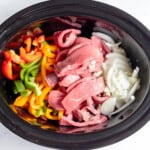 A crock pot filled with meat and vegetables.