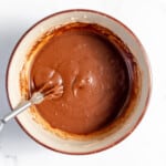 Chocolate sauce in a bowl with a spoon.