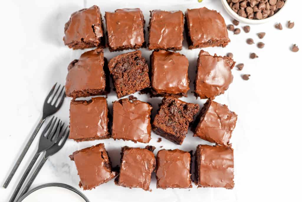 Chocolate brownies on a white plate with a fork.