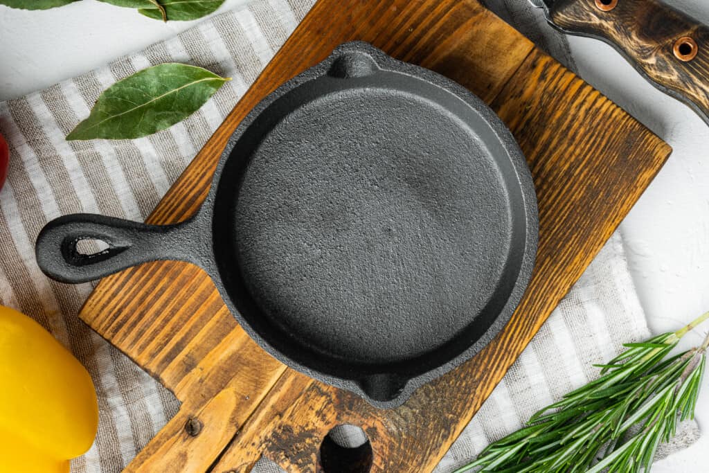A clean cast iron skillet on a wooden cutting board.