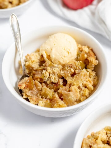 Apple crisp in a bowl with ice cream.