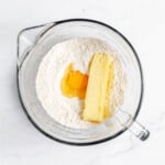 A bowl with flour, eggs and butter in it.