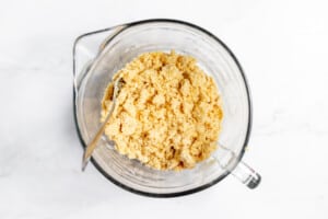 A glass bowl filled with a mixture of flour and sugar.