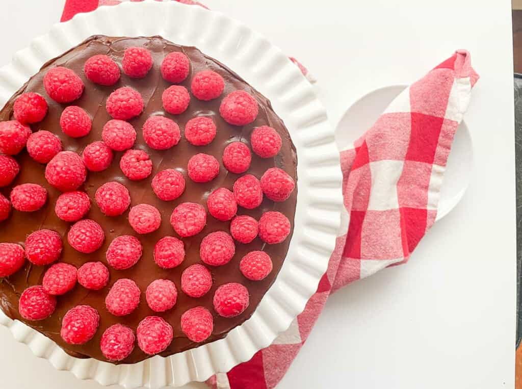A chocolate fudge cake with raspberries on top.