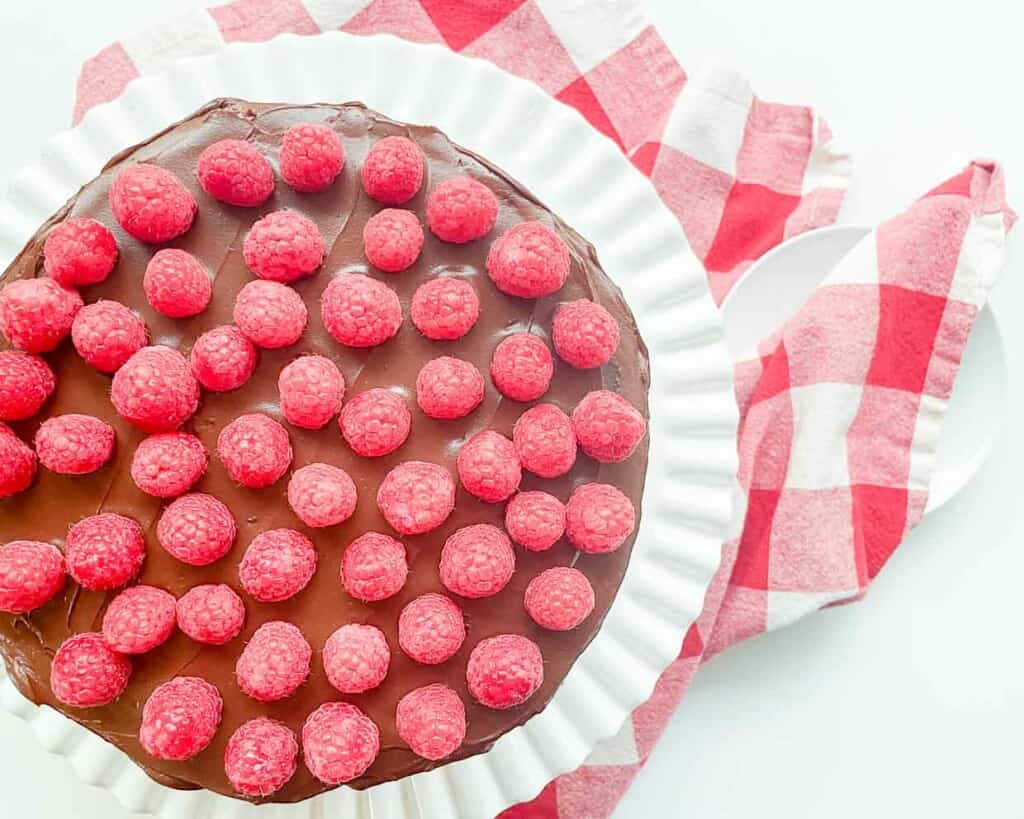 A chocolate fudge cake with raspberries on top.