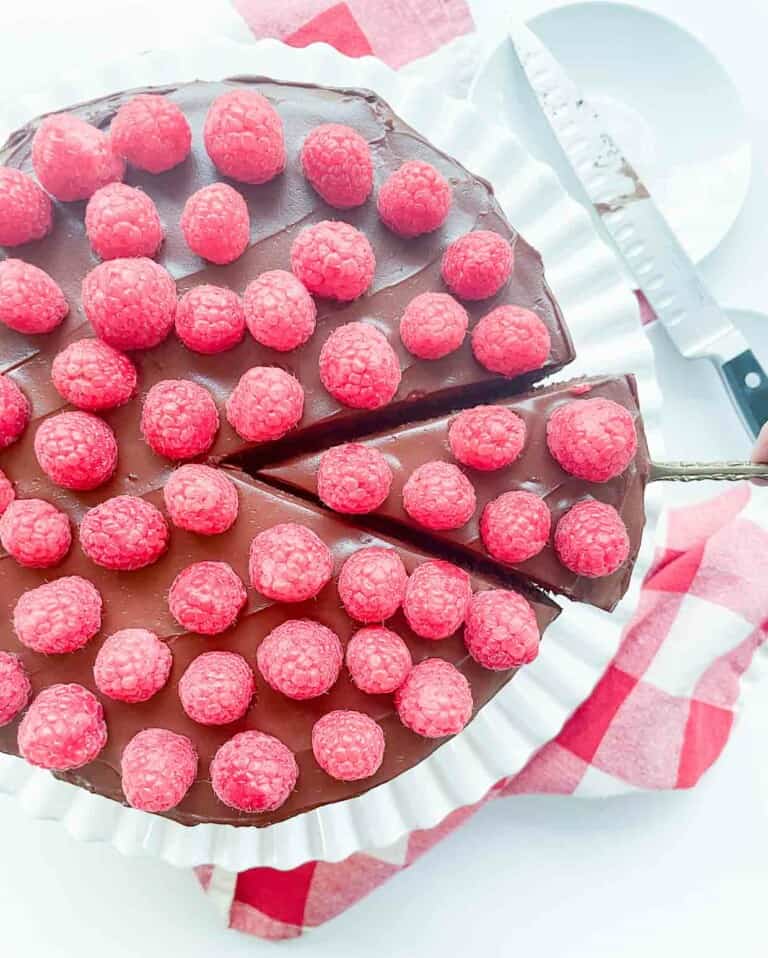 A chocolate fudge cake with raspberries on top.
