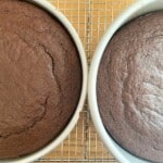 Two chocolate fudge cakes on a cooling rack.