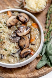 Wild mushroom risotto in a bowl with parmesan cheese and sage.