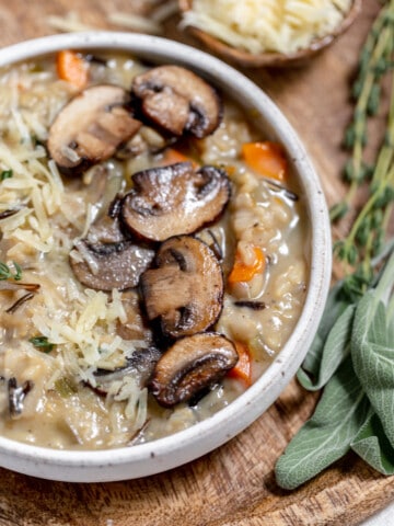 Wild mushroom risotto in a bowl with parmesan cheese and sage.