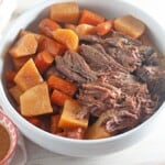 A bowl of beef stew with carrots and potatoes.