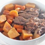 A bowl of roast beef with carrots and potatoes.
