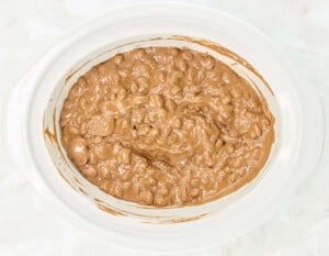 A crockpot filled with chocolate nut cluster candy makings.