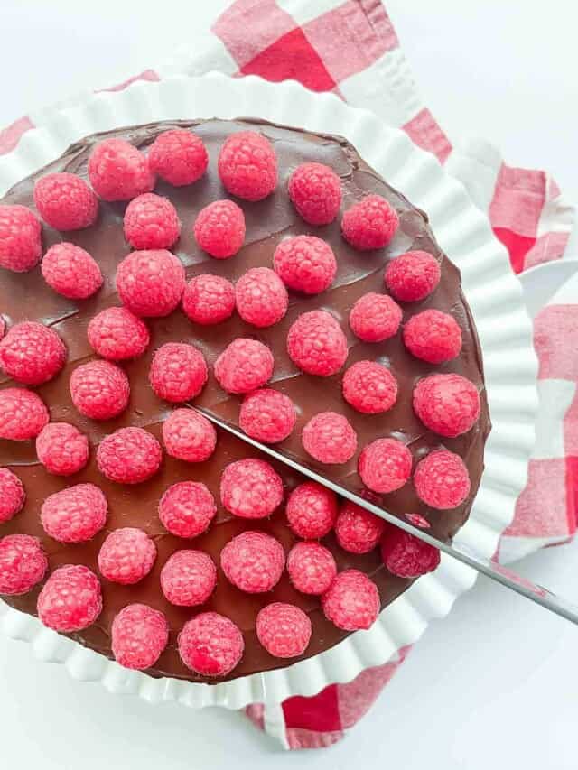 A chocolate pie with raspberries on top.