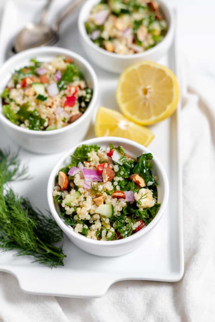 Three bowls of couscous salad on a white plate.