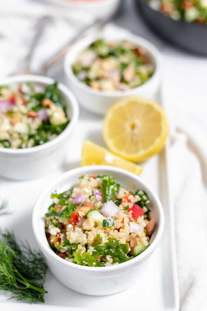 Three bowls of quinoa salad on a white plate.