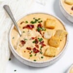 A bowl of cheese soup with croutons and croutons.