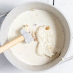 A pot of cream with a spatula in it.