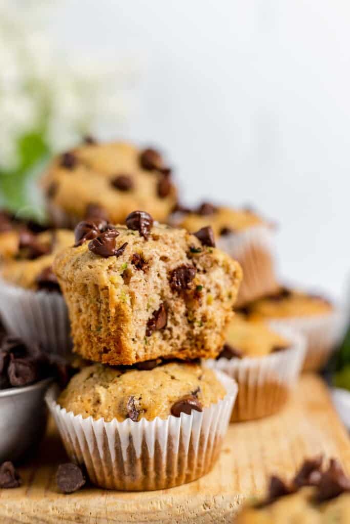 A stack of chocolate chip muffins on a cutting board.