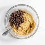 Chocolate chip cookie dough in a bowl with chocolate chips.