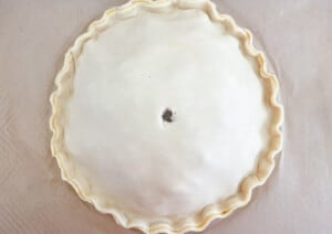 A pie crust is being made on a baking sheet.