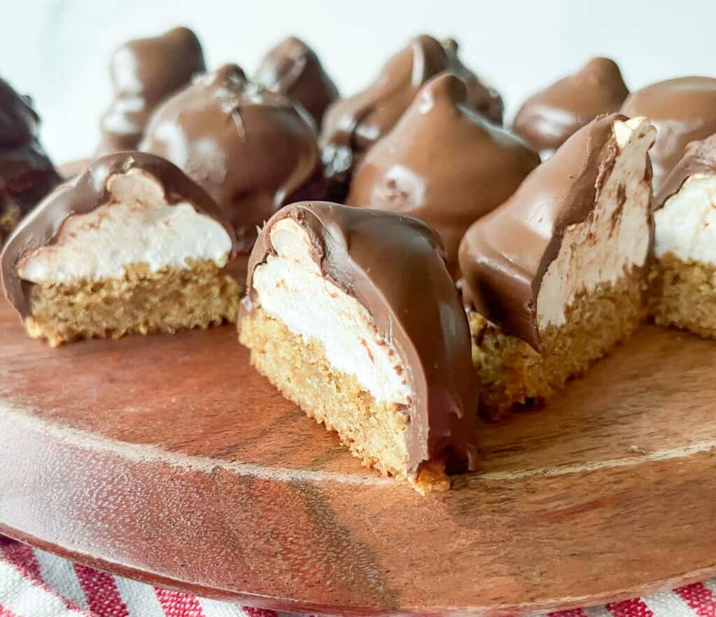 Chocolate covered mallowmars on a wooden cutting board.