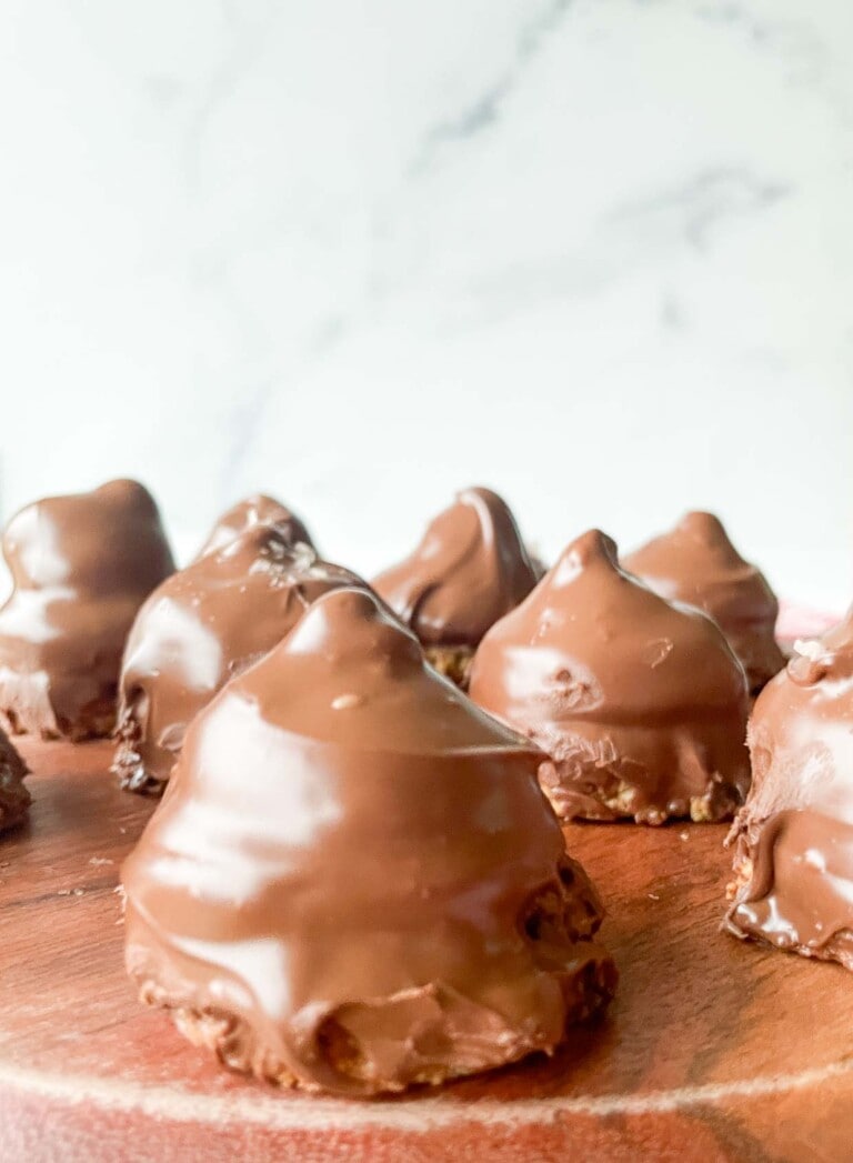 Chocolate covered cookies on a wooden board with mallowmars.