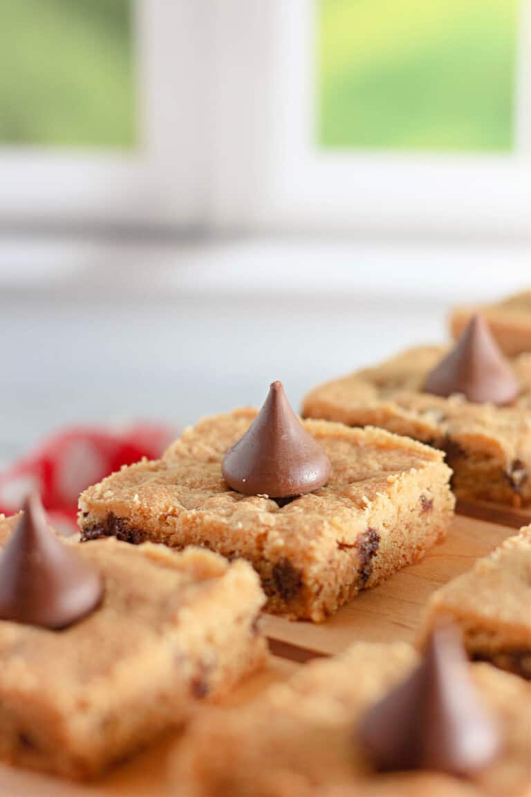 Chocolate chip cookie bars on a wooden cutting board.