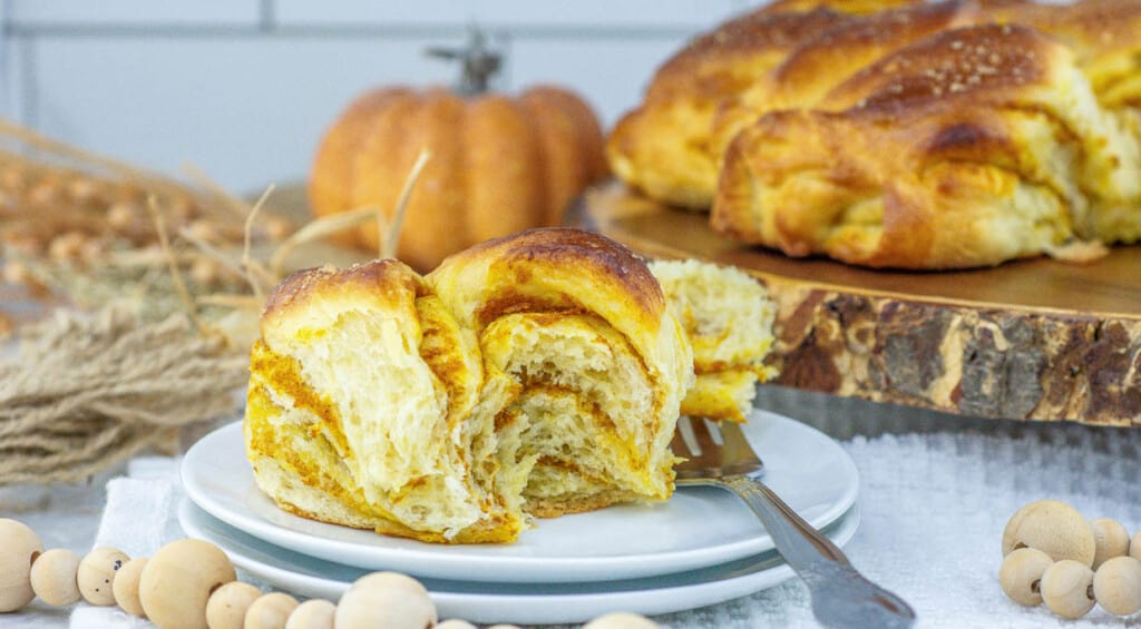 A slice of pumpkin bread on a plate with a fork.