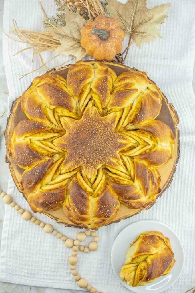 A pumpkin pie on a table with a slice of pie.
