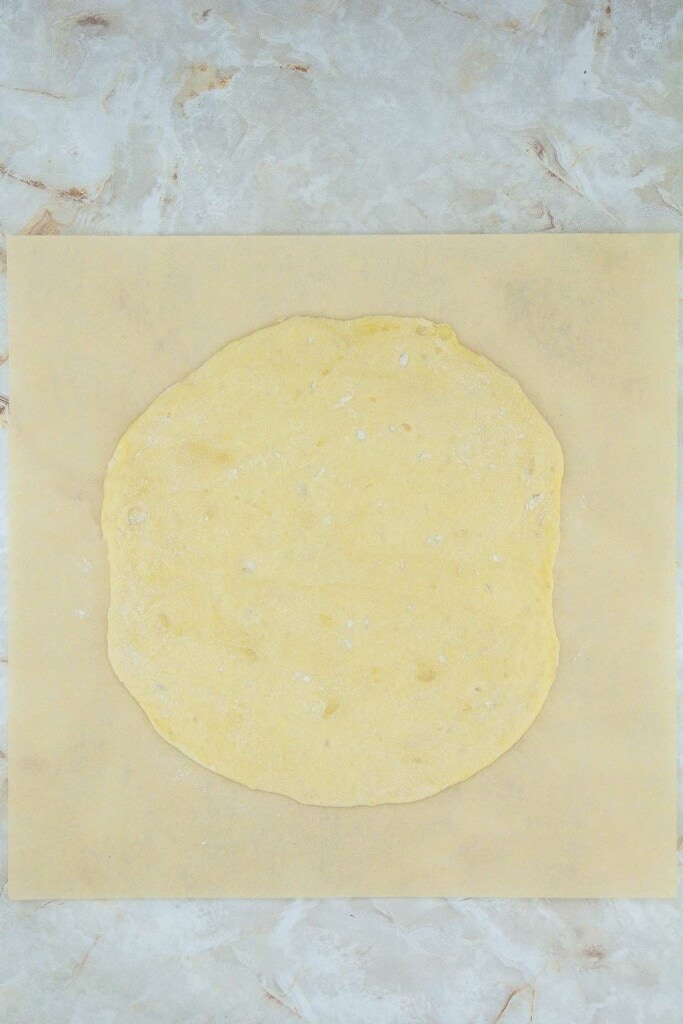 A piece of dough on a marble surface.