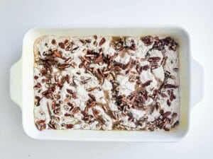 A white baking dish filled with sweet potato and cake mix.