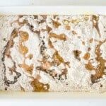 A white baking dish cake mix and butter drizzled over it.