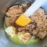 A mixture of butter and sugar in a metal bowl.