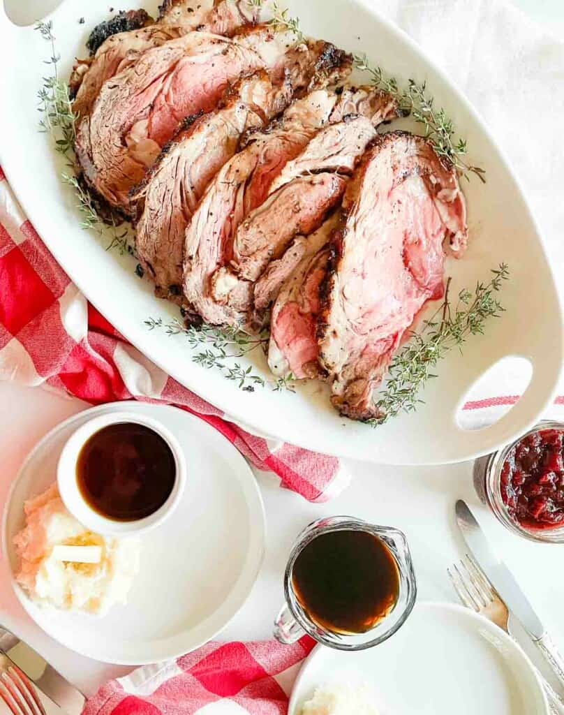 Prime rib roast with cranberry sauce on a white plate.