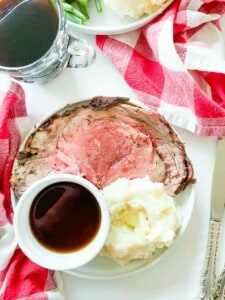 A plate of prime rib roast with gravy and mashed potatoes.