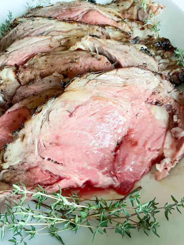 A plate of roasted beef with sprigs of thyme.