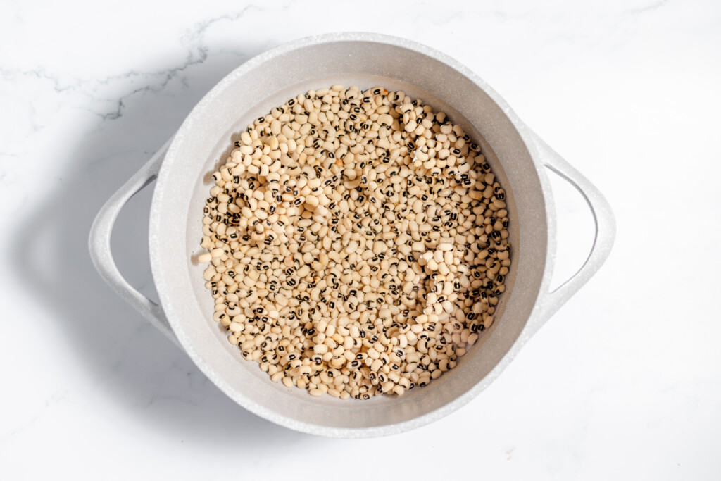 A white bowl filled with seeds on a marble countertop.