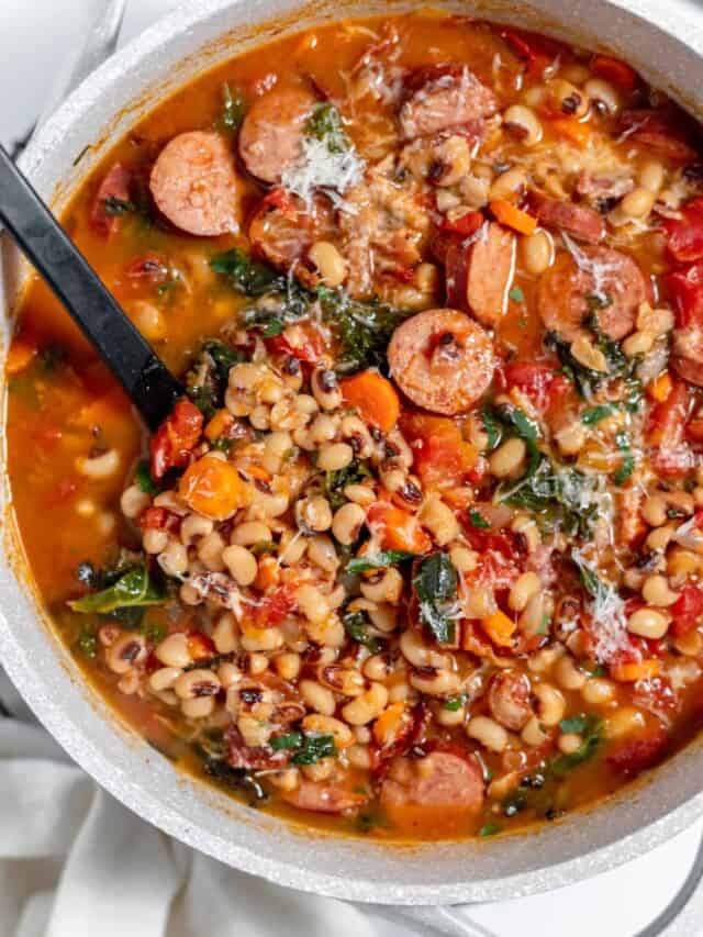 A pot of black eyed pea soup with sausage and spinach.