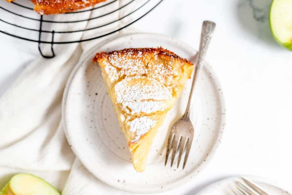 A slice of apple pie on a plate with a fork.