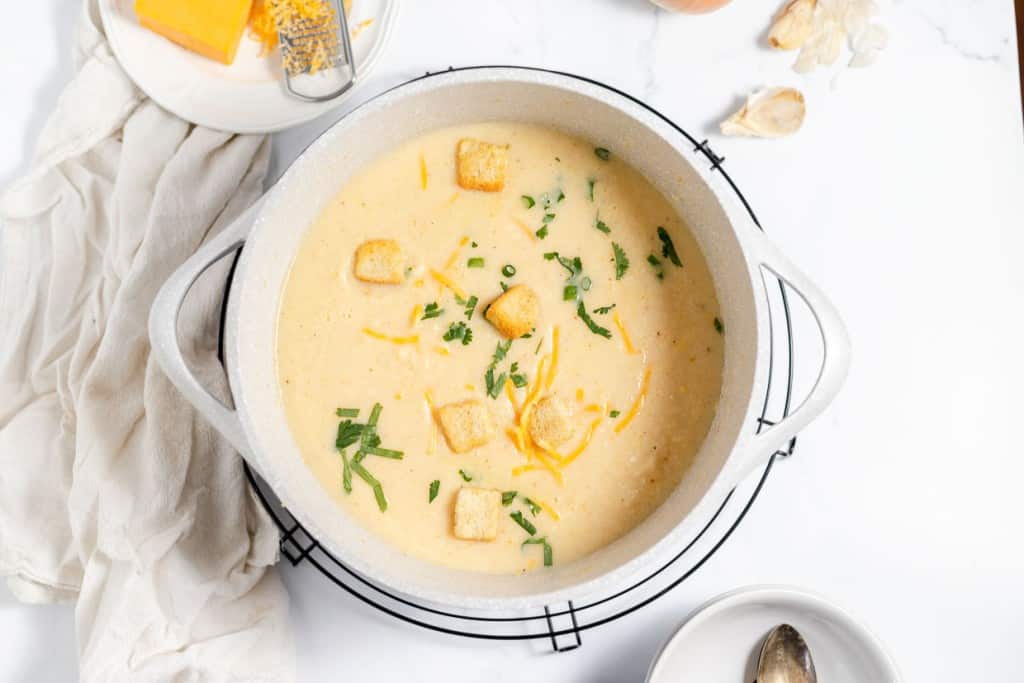 A bowl of soup with croutons and cheese.