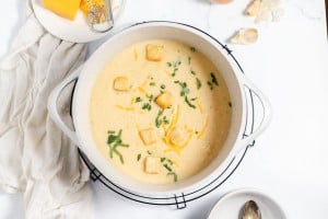 A bowl of soup with croutons and cheese.