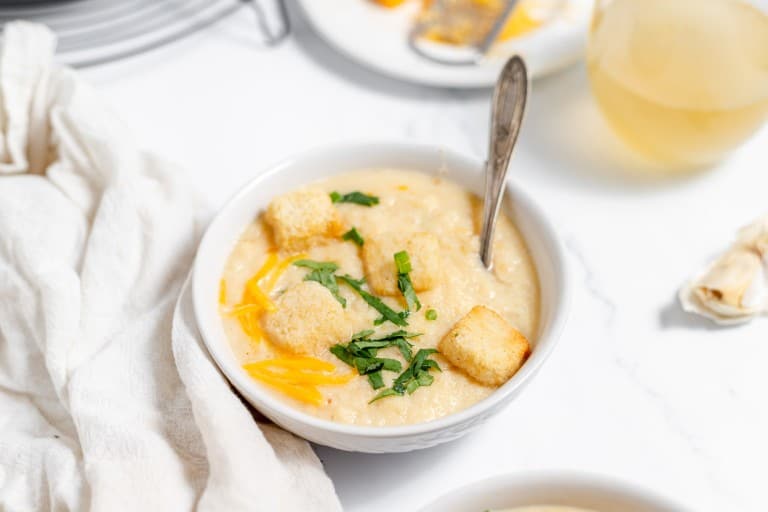 A bowl of soup with croutons and garlic.