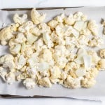 Cauliflower florets on a baking sheet.