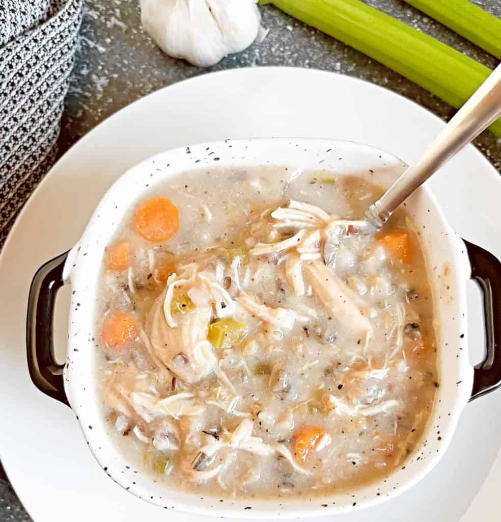 A bowl of chicken noodle soup with celery and carrots.