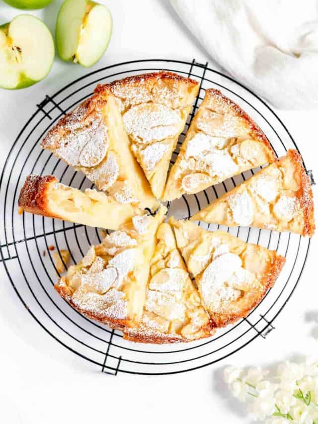 A slice of apple cake on a cooling rack.
