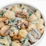 Mushroom and spinach dumplings in a white bowl.
