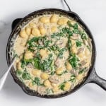 A skillet filled with mushrooms and spinach.
