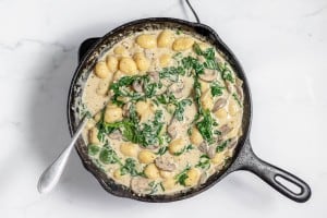 A skillet filled with mushrooms and spinach.
