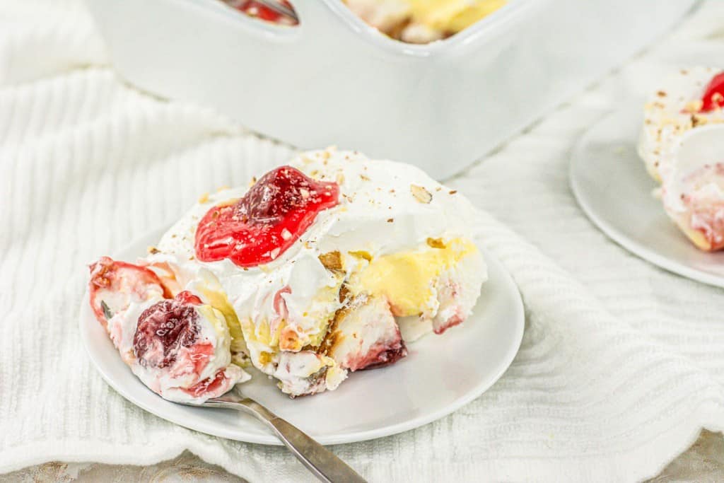 A white plate with a piece of cake on it.